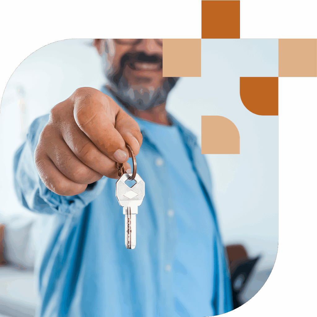 Mann hält Schlüssel in der Hand.