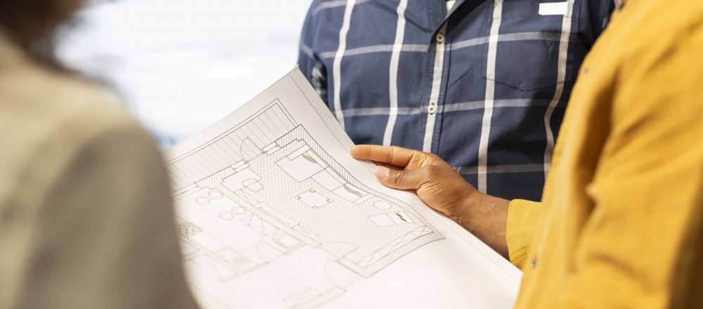 Menschen betrachten einen Bauplan zusammen.